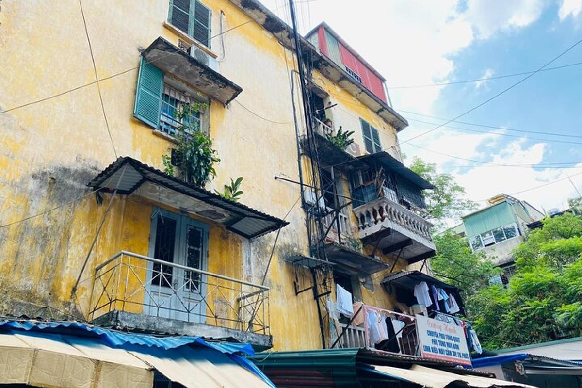 Stará žlutá budova s okny a balkony