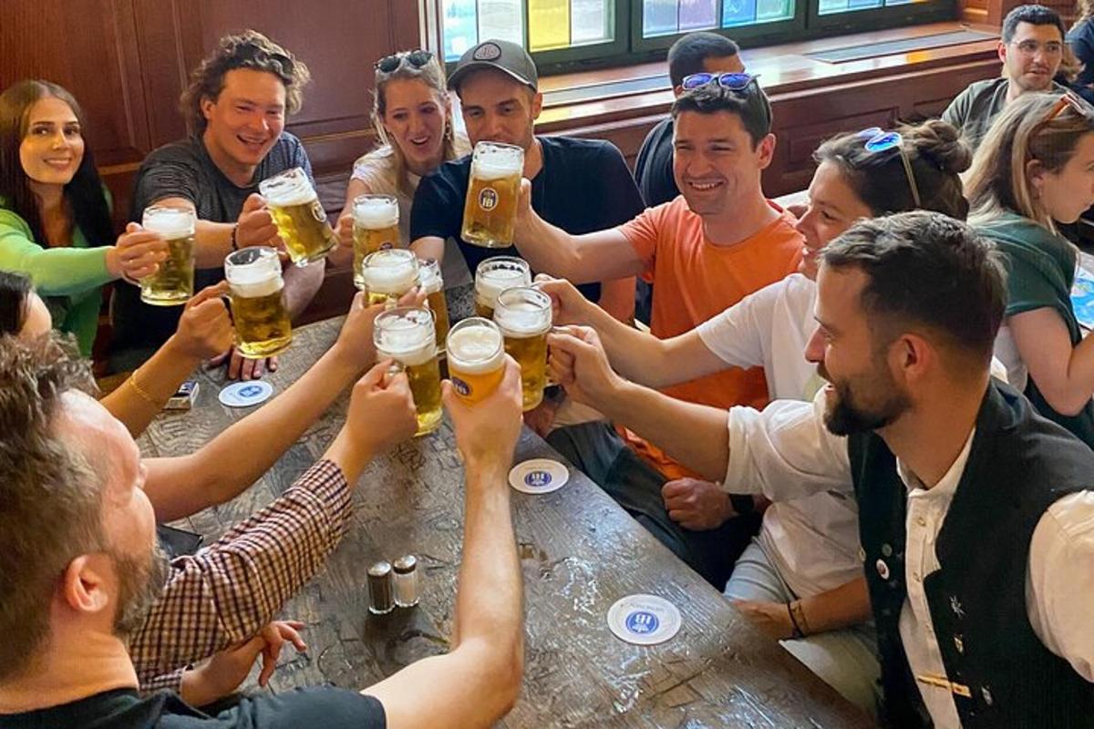 un grup de persones assegudes al voltant d'una taula bevent cervesa