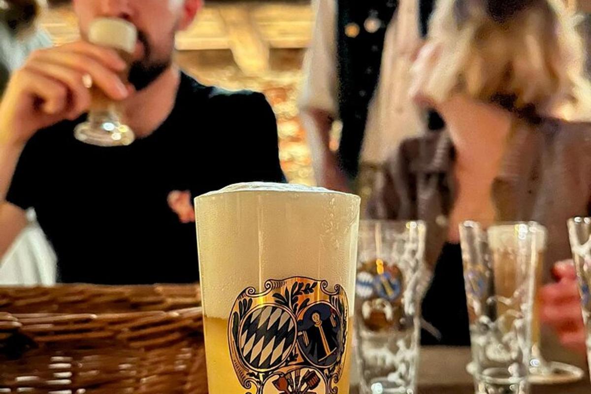ein Mann, der an einem Tisch sitzt und aus einem Glas trinkt