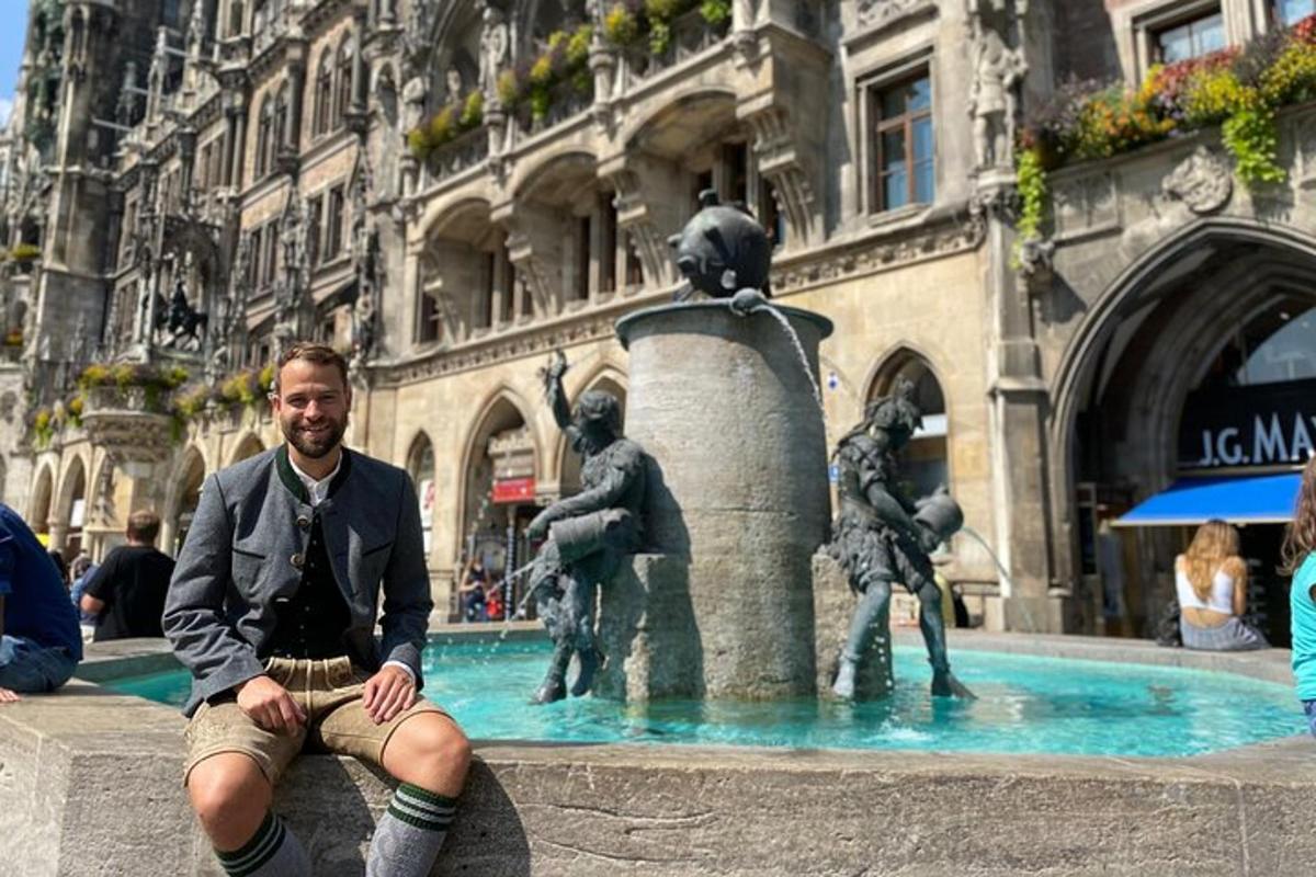 ein Mann sitzt vor einem Brunnen