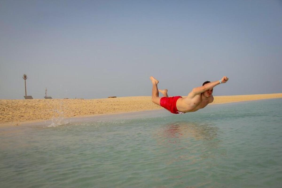 moški skače v vodo na plaži