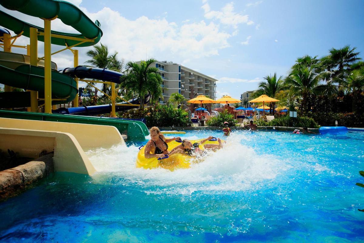 a group of people riding a water slide at a resort