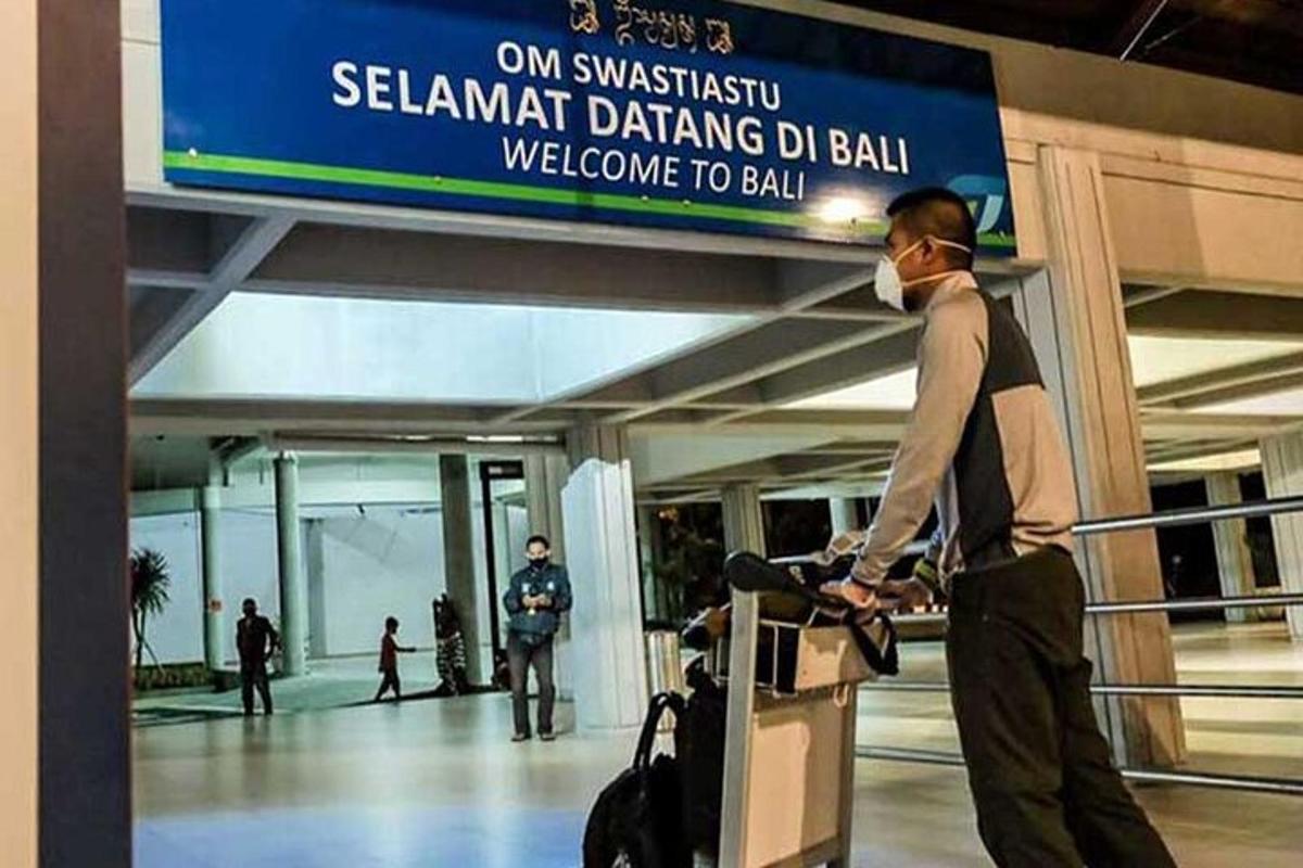 một người đàn ông đeo khẩu trang đứng ở sân bay
