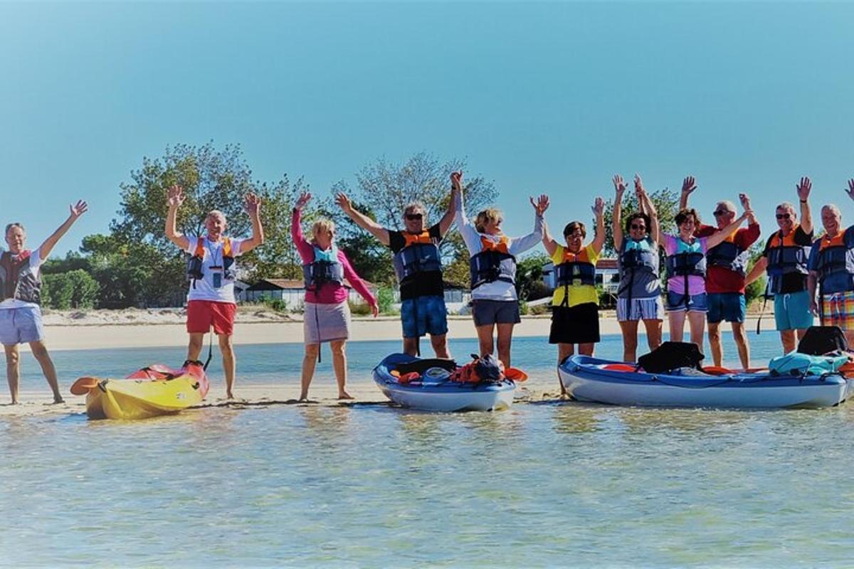 Un grupo de personas de pie en el agua en una playa.
