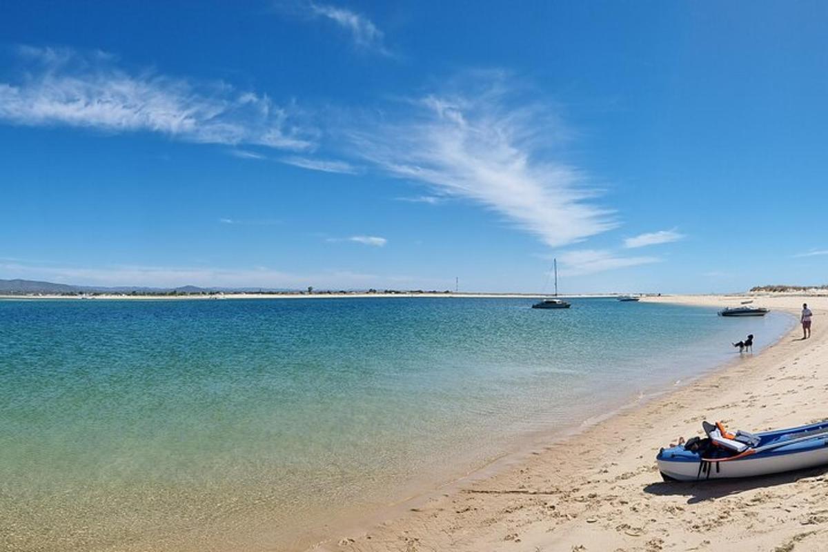 Una playa con un barco en la arena y el agua.