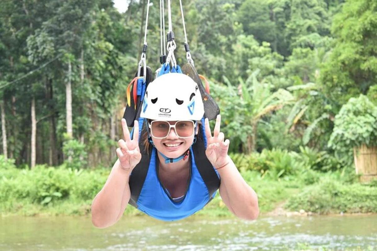 a person in a helmet on a swing over a river