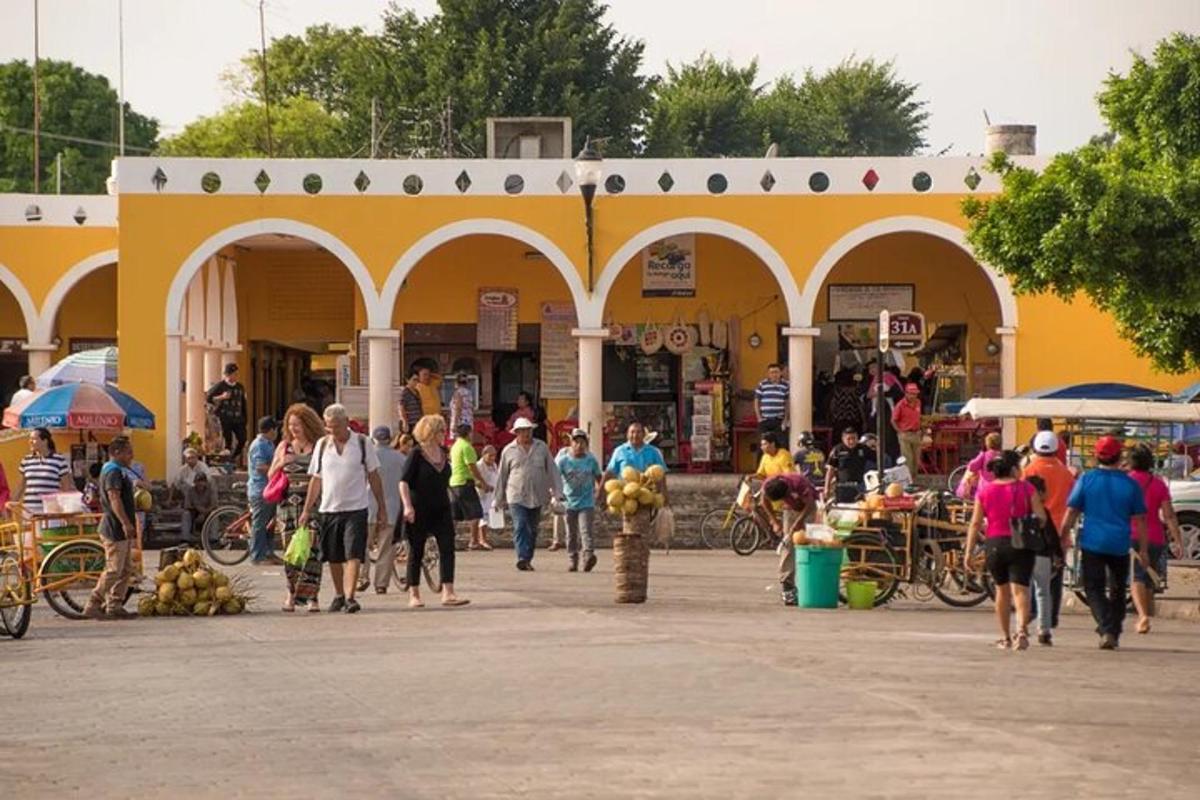 un grup de persones caminant davant d'un edifici groc