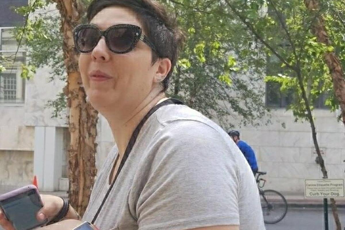 žena se slunečními brýlemi drží mobilní telefon