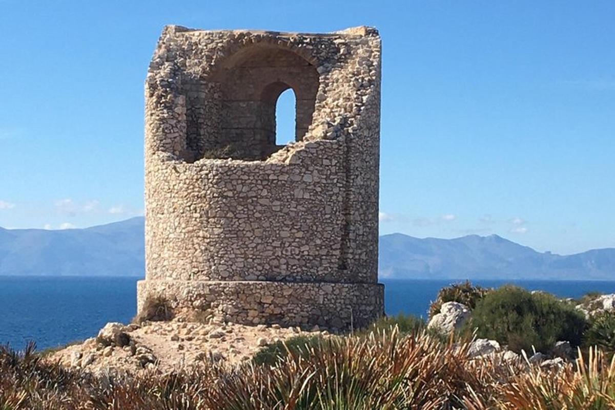 a tower on top of a hill next to the ocean