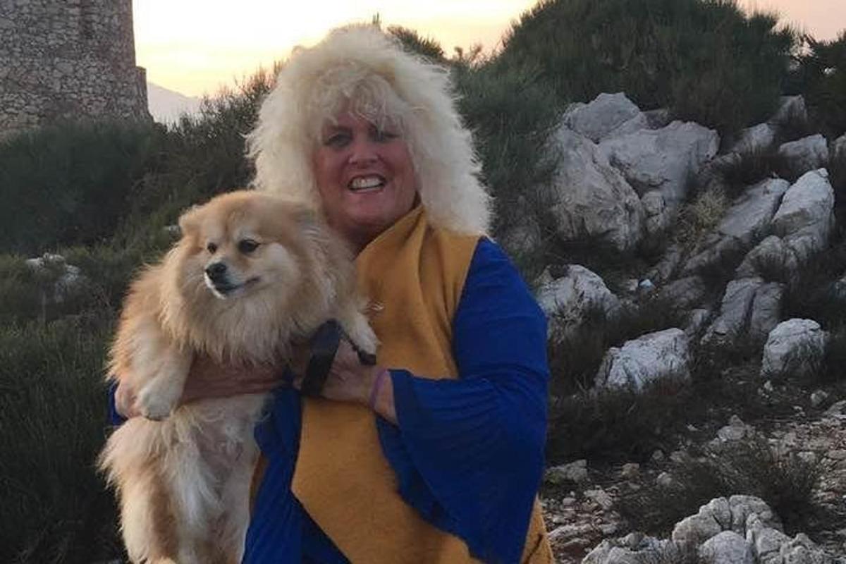 a woman holding a dog in her arms