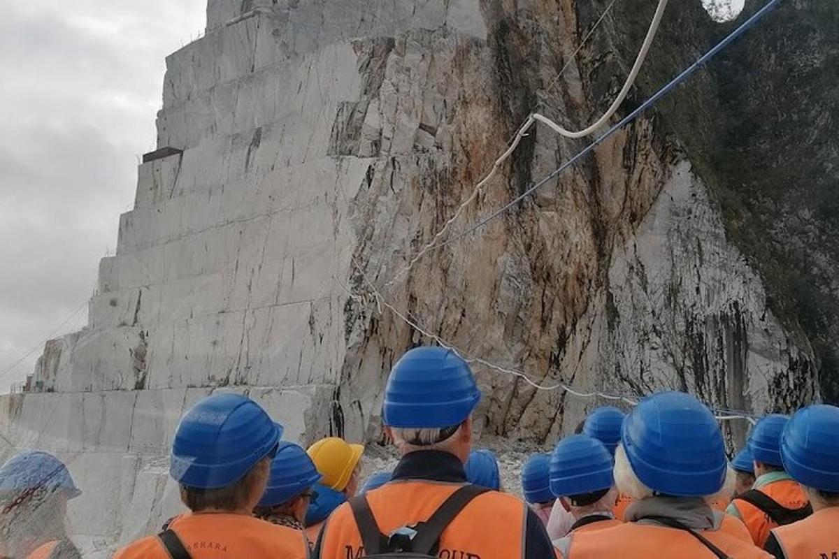 un grup de treballadors amb barrets blaus mirant un penya-segat