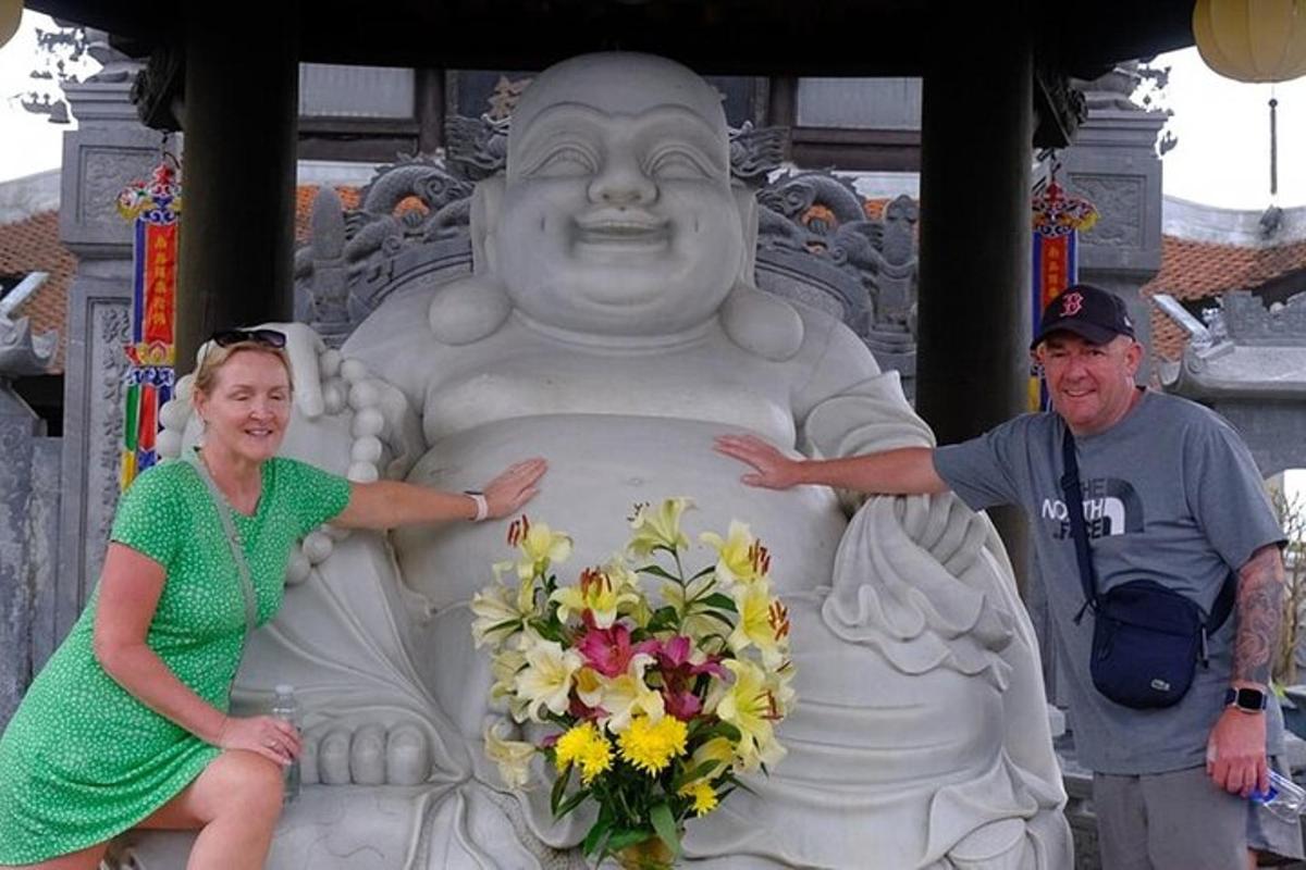 um homem e uma mulher em pé ao lado de uma estátua