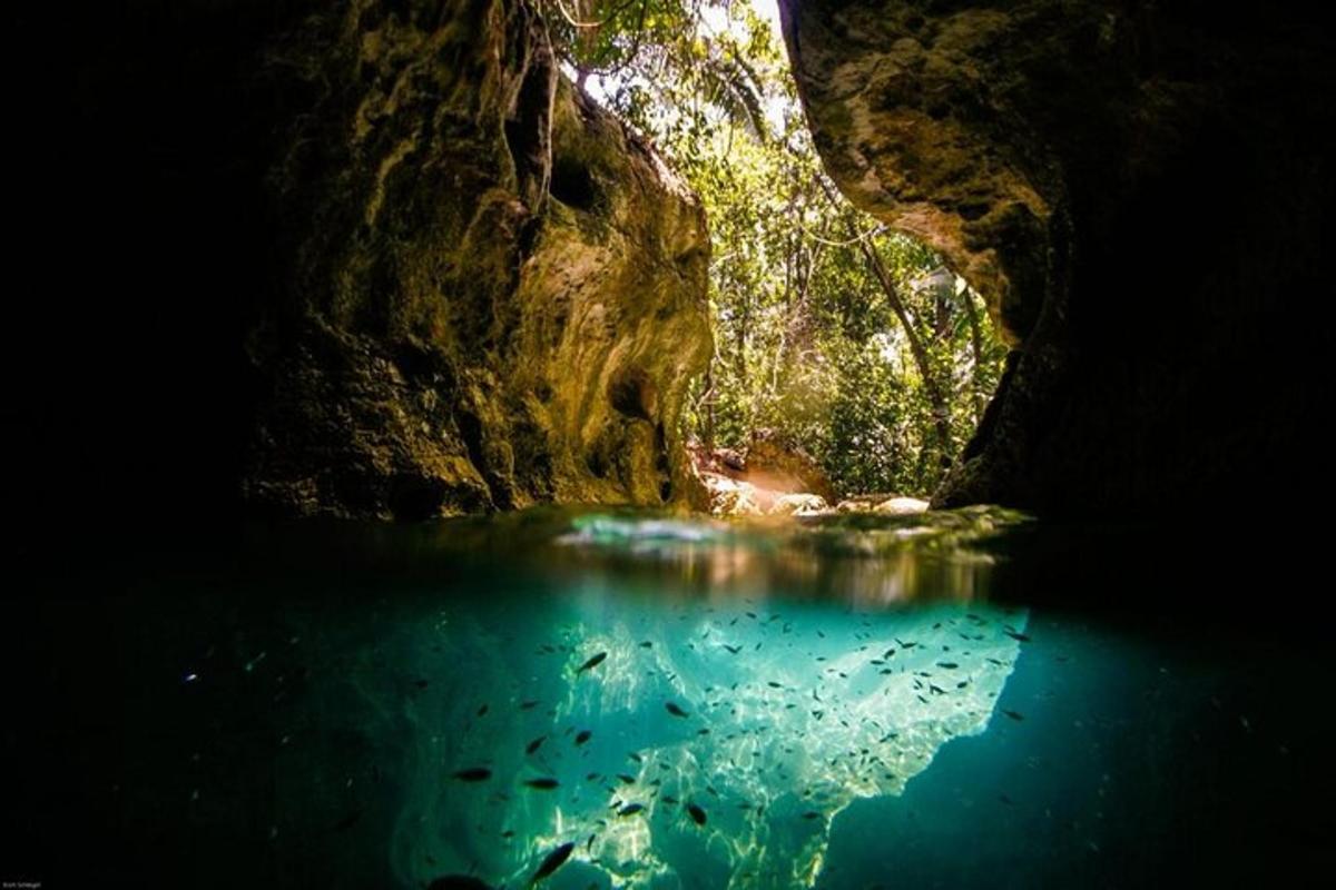 a cave with a pool of blue water in it