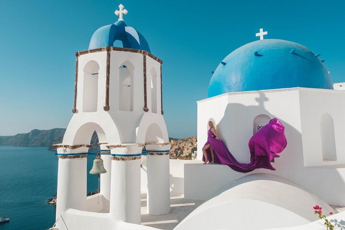 Una mujer sentada al costado de una iglesia con una cúpula azul.