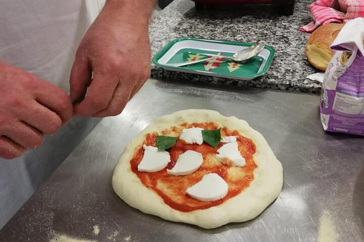 en person som lager pizza på et bord
