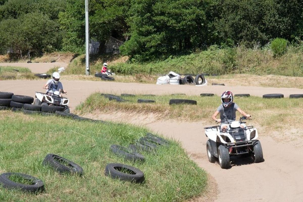 dva lidé jedoucí na čtyřkolkách po nezpevněné cestě