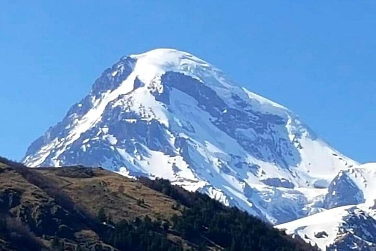una montagna coperta di neve con un cielo azzurro sullo sfondo