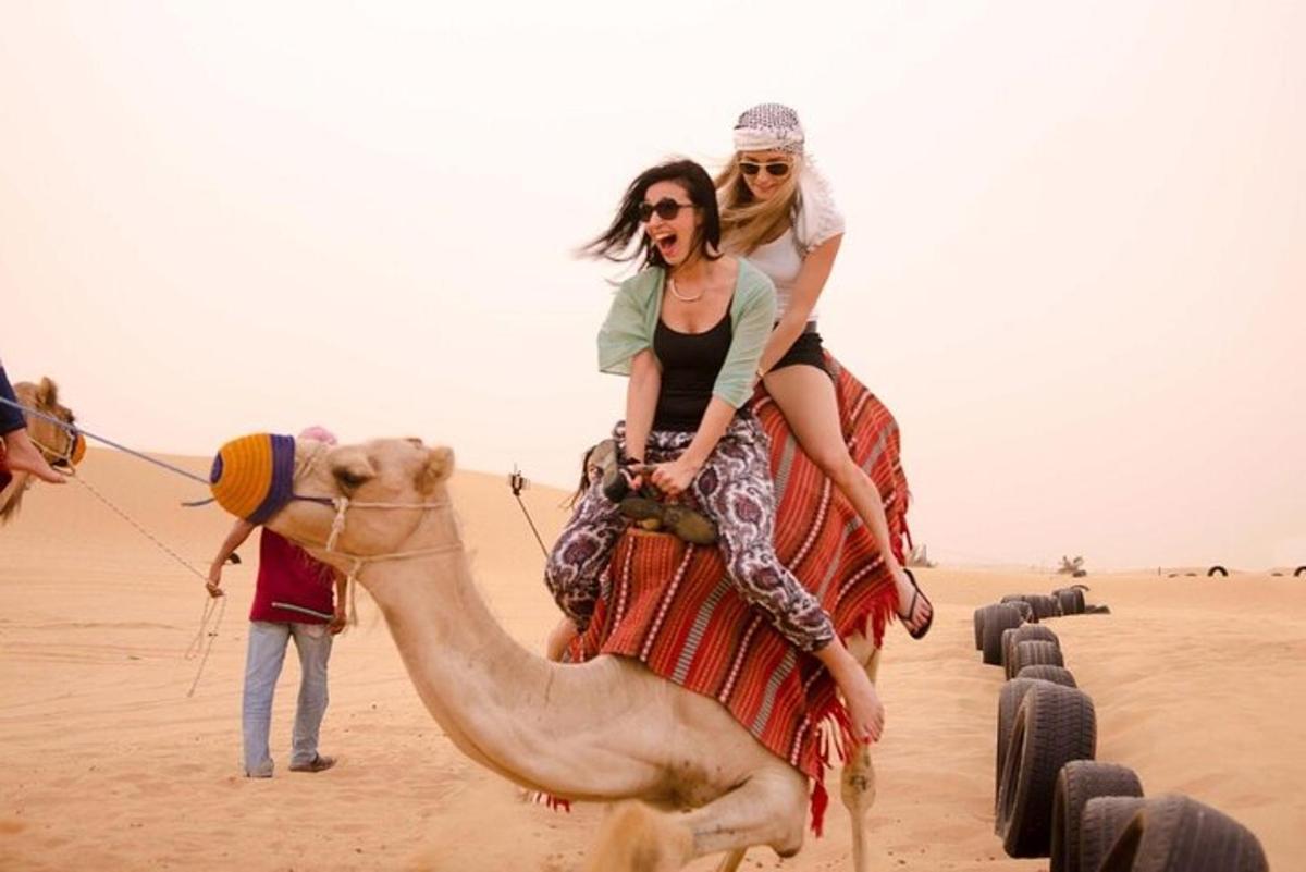 two women riding on a camel in the desert