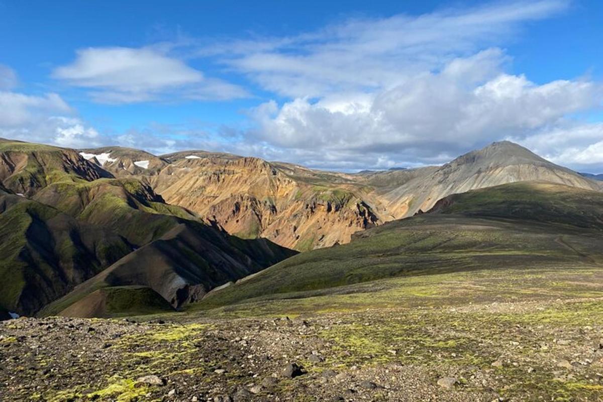 Blick auf eine Bergkette mit grünen Hügeln