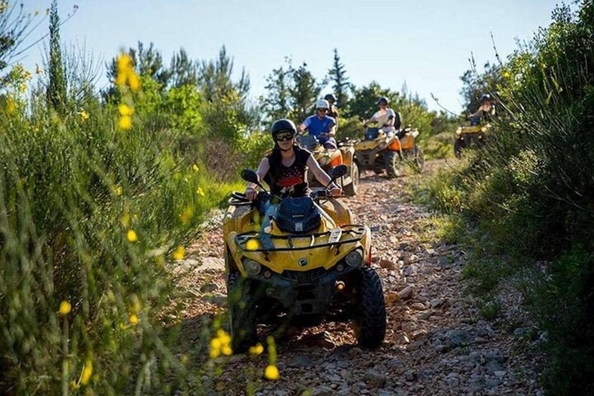 un gruppo di persone che guidano quad su una strada sterrata