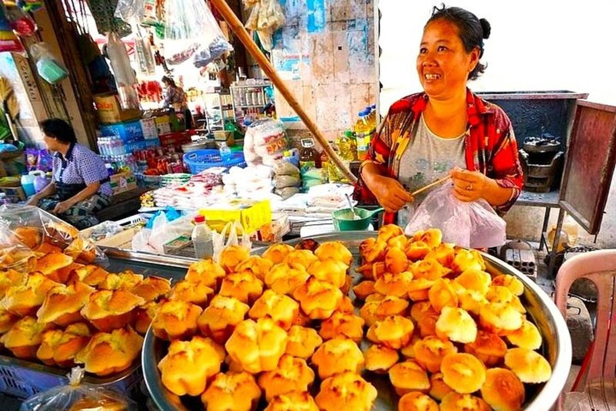 一位女士站在市场里，手里拿着一堆橘子