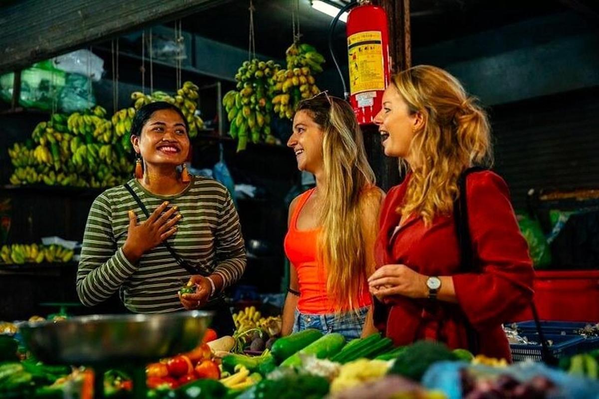 tres dones dempeus en un mercat amb productes