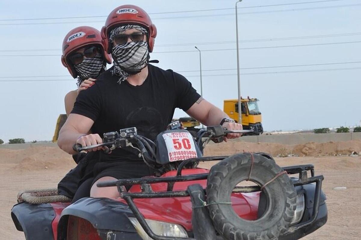 due uomini che indossano caschi e maschere in sella a un quad