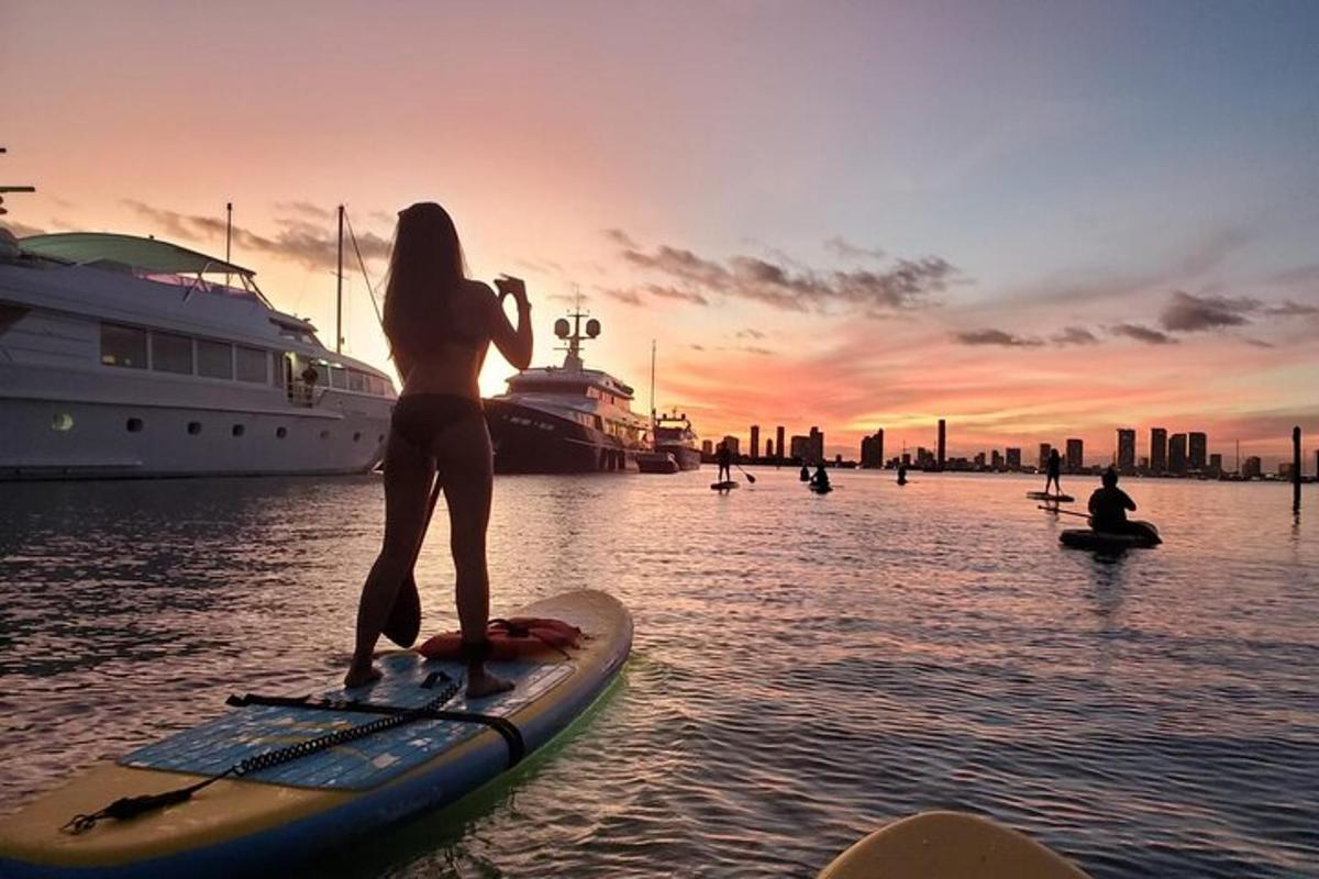 una donna è in piedi su una tavola da paddle in acqua