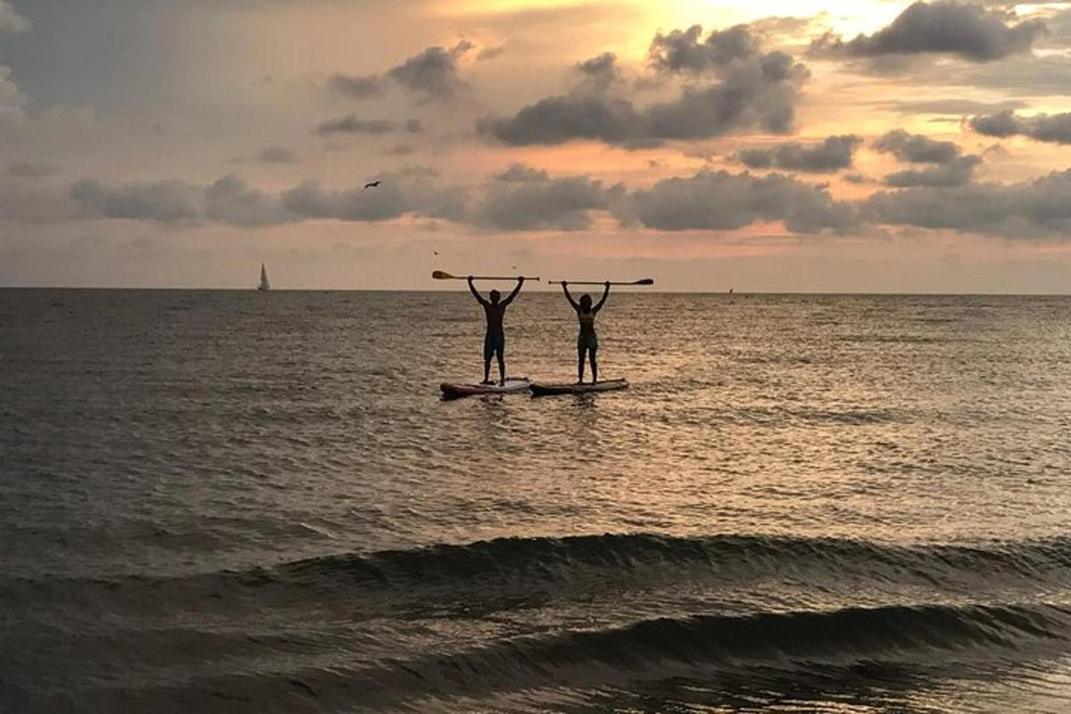 due persone in piedi su una tavola da paddle nell'oceano