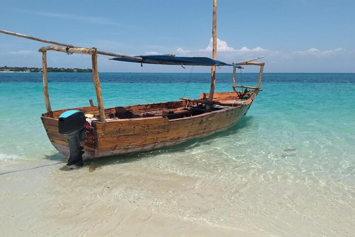 a wooden boat sitting in the water on a beach