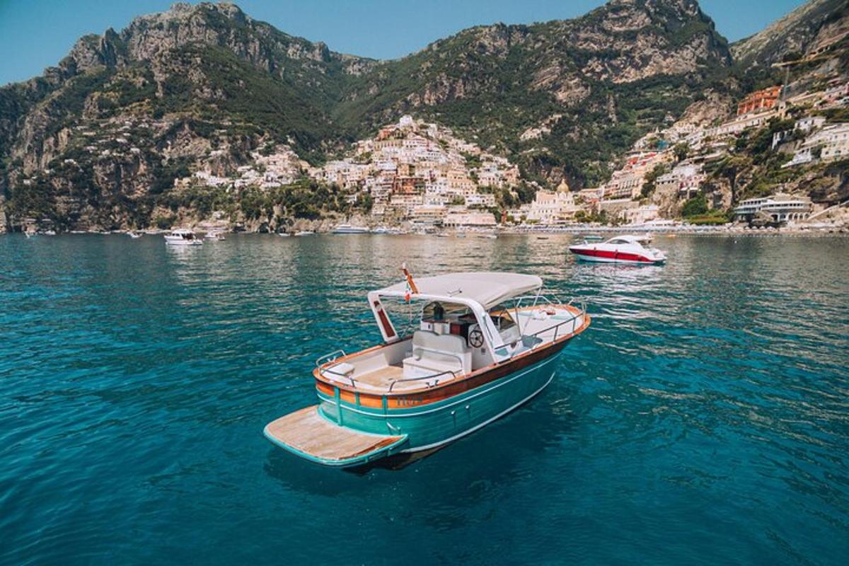 una piccola barca in acqua con le montagne sullo sfondo