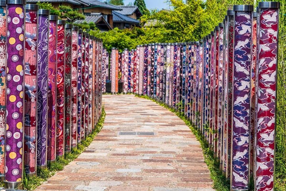 a fence covered in colorful ties on a sidewalk