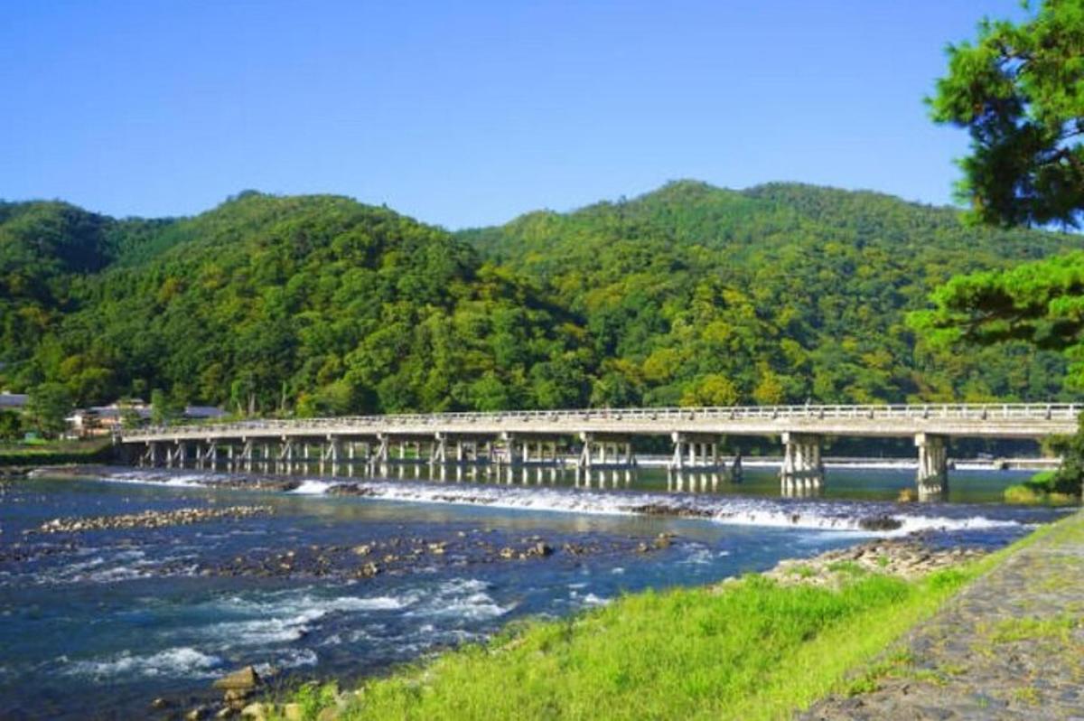 uma ponte sobre um rio com montanhas ao fundo