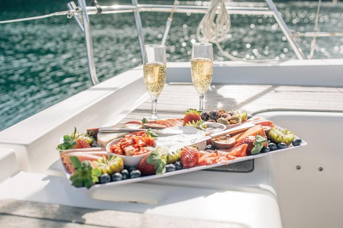 dulang makanan di atas bot dengan gelas champagne