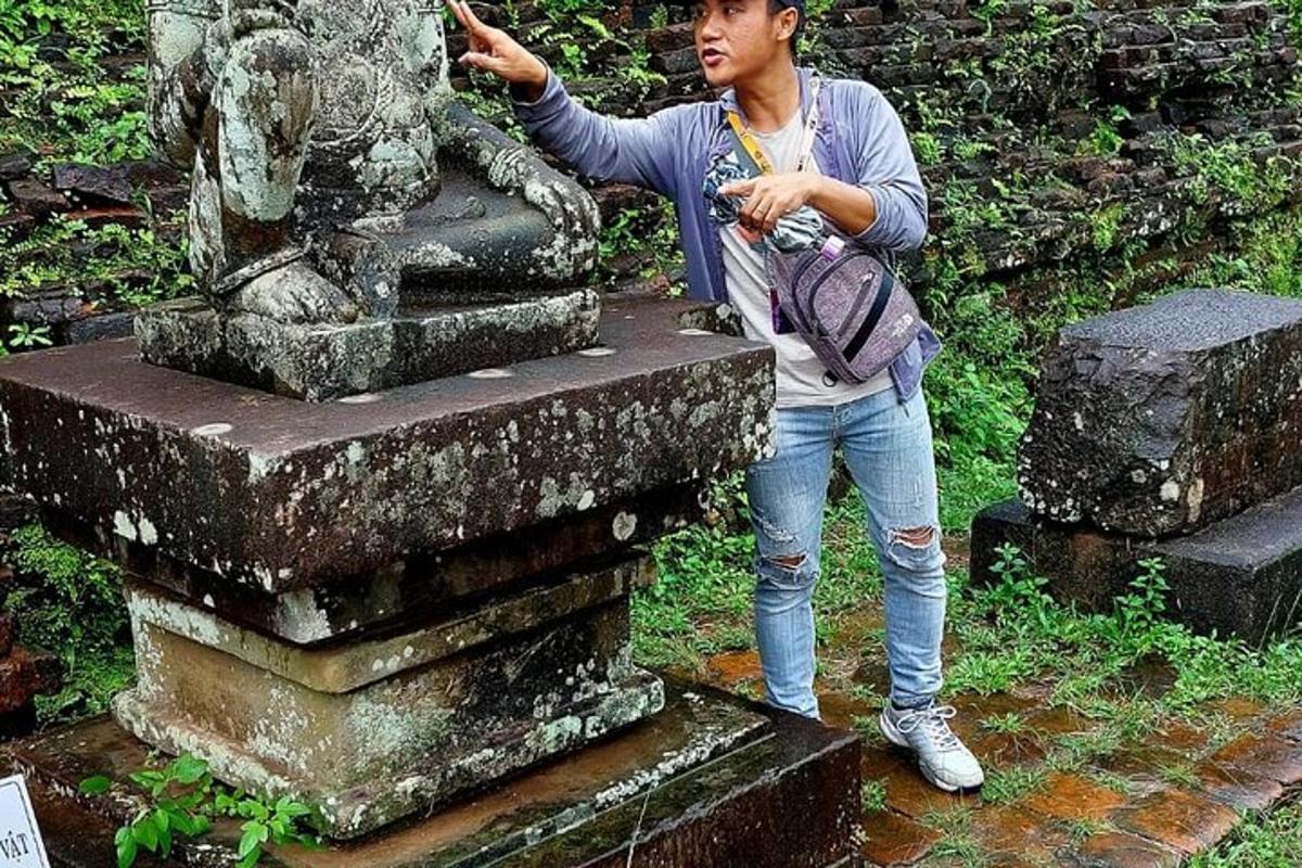 un uomo con uno zaino in piedi accanto a una statua