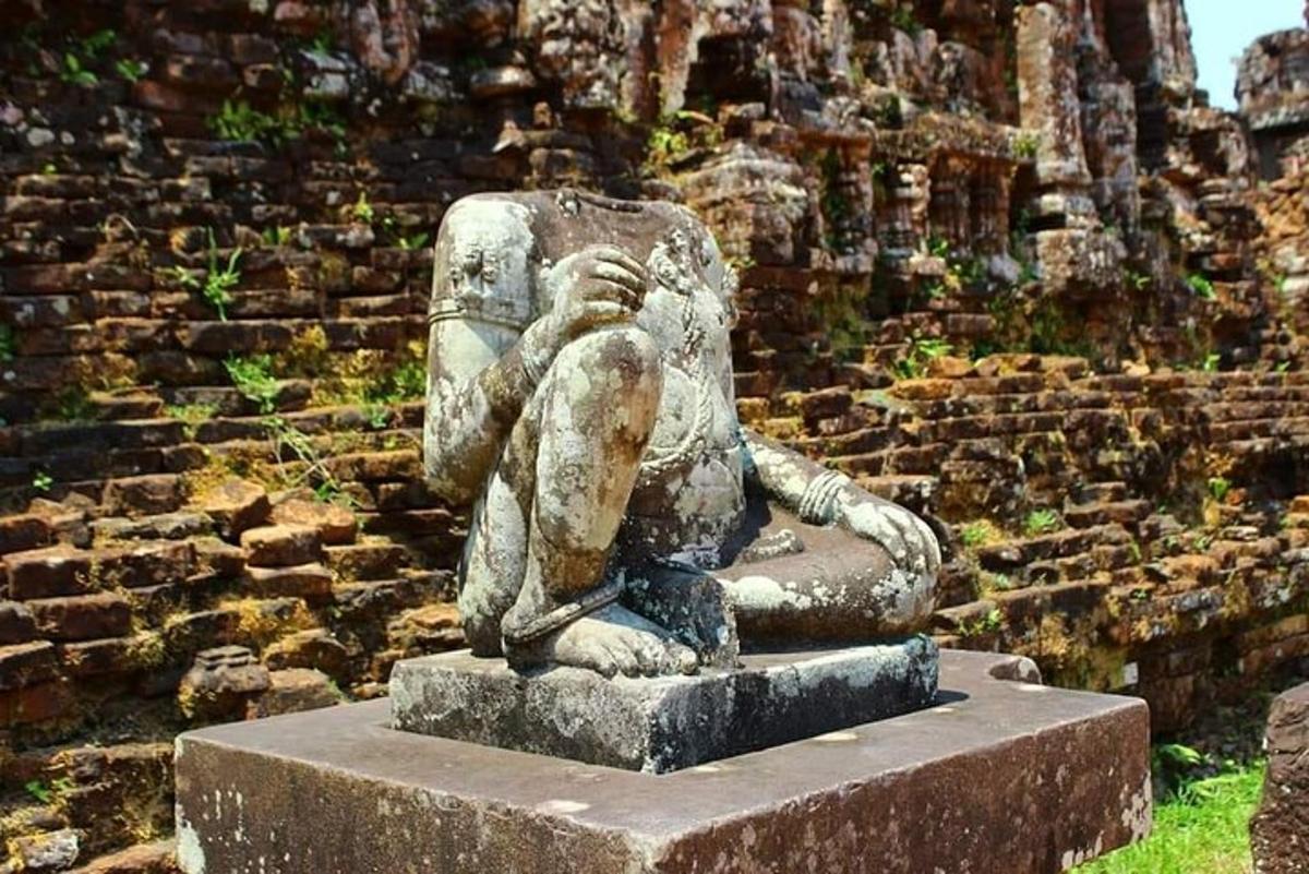 una statua di una donna seduta davanti a un muro