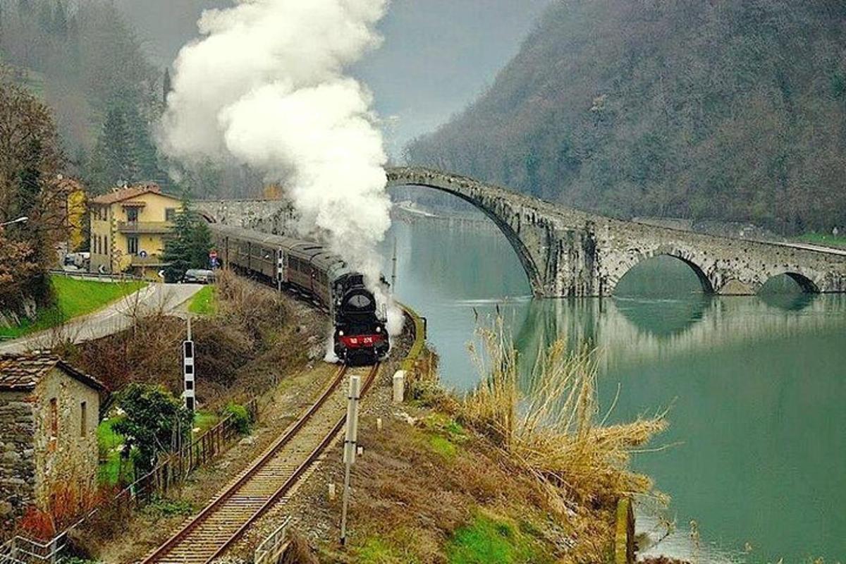 a train traveling down the tracks near a bridge