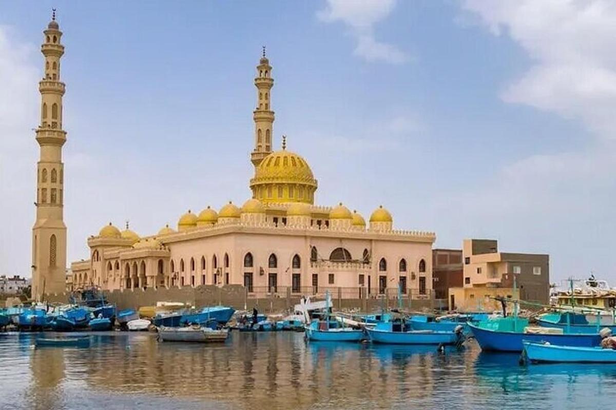 um grande edifício com uma mesquita com barcos na água