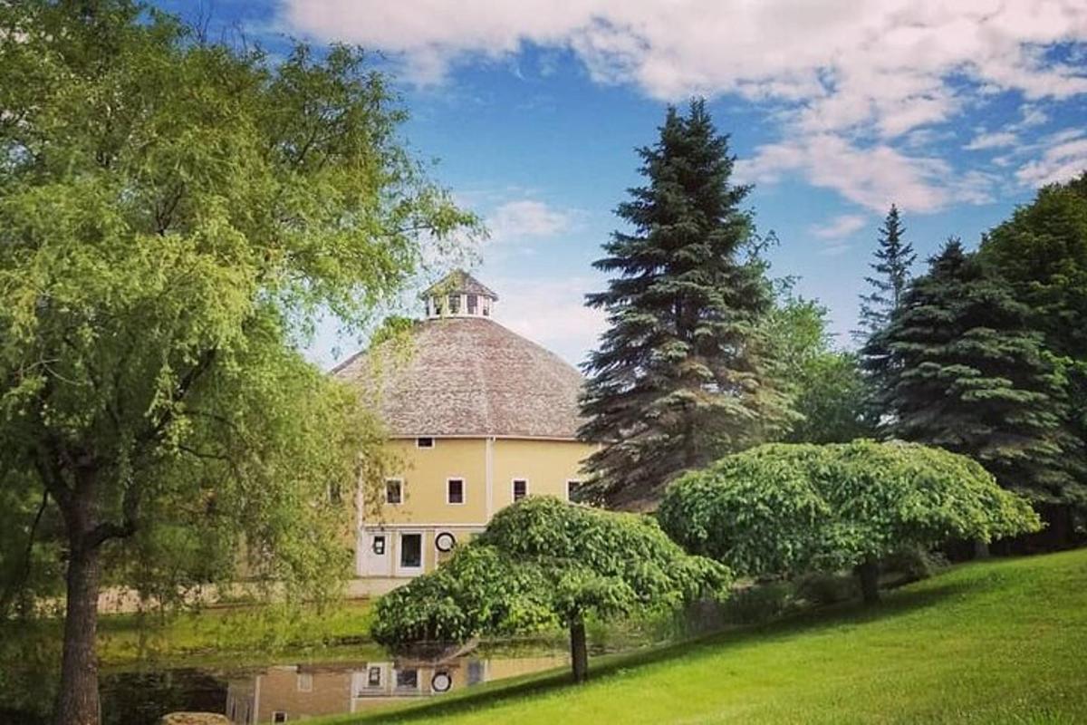 a large white house with a tree in a field
