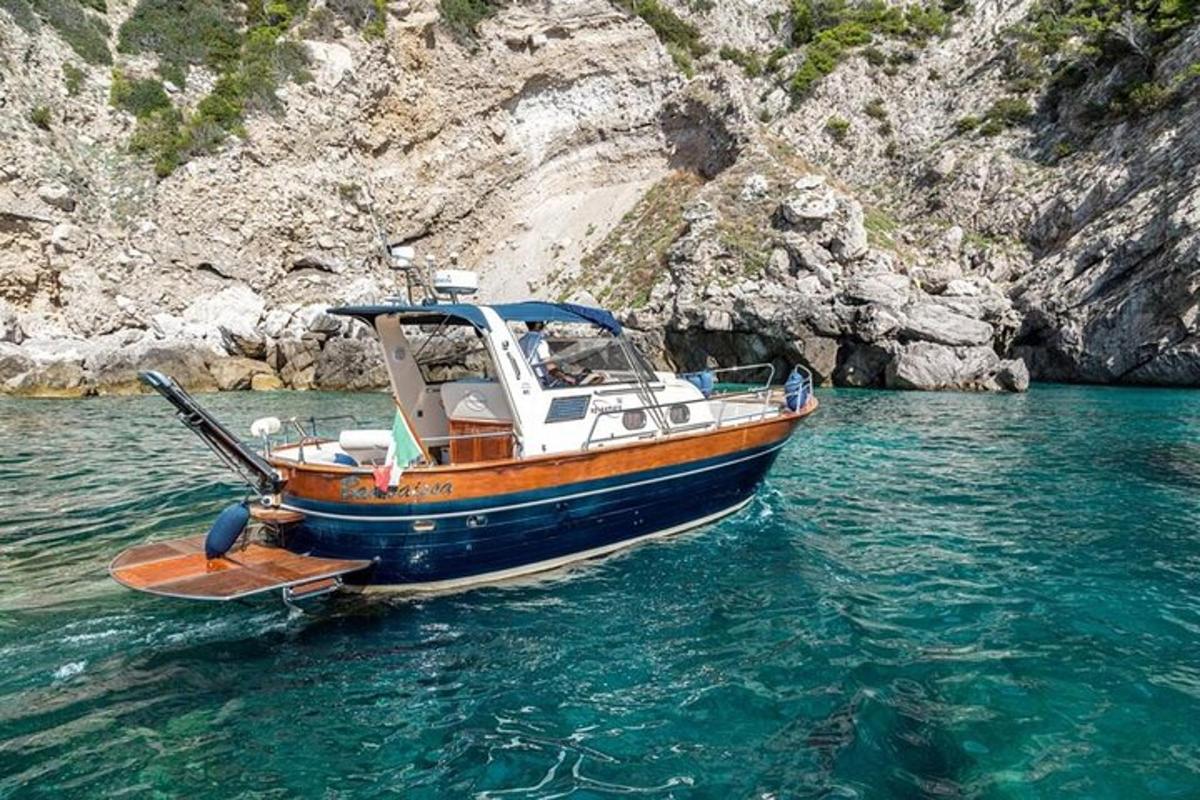 μια βάρκα που κάθεται στο νερό δίπλα σε έναν γκρεμό