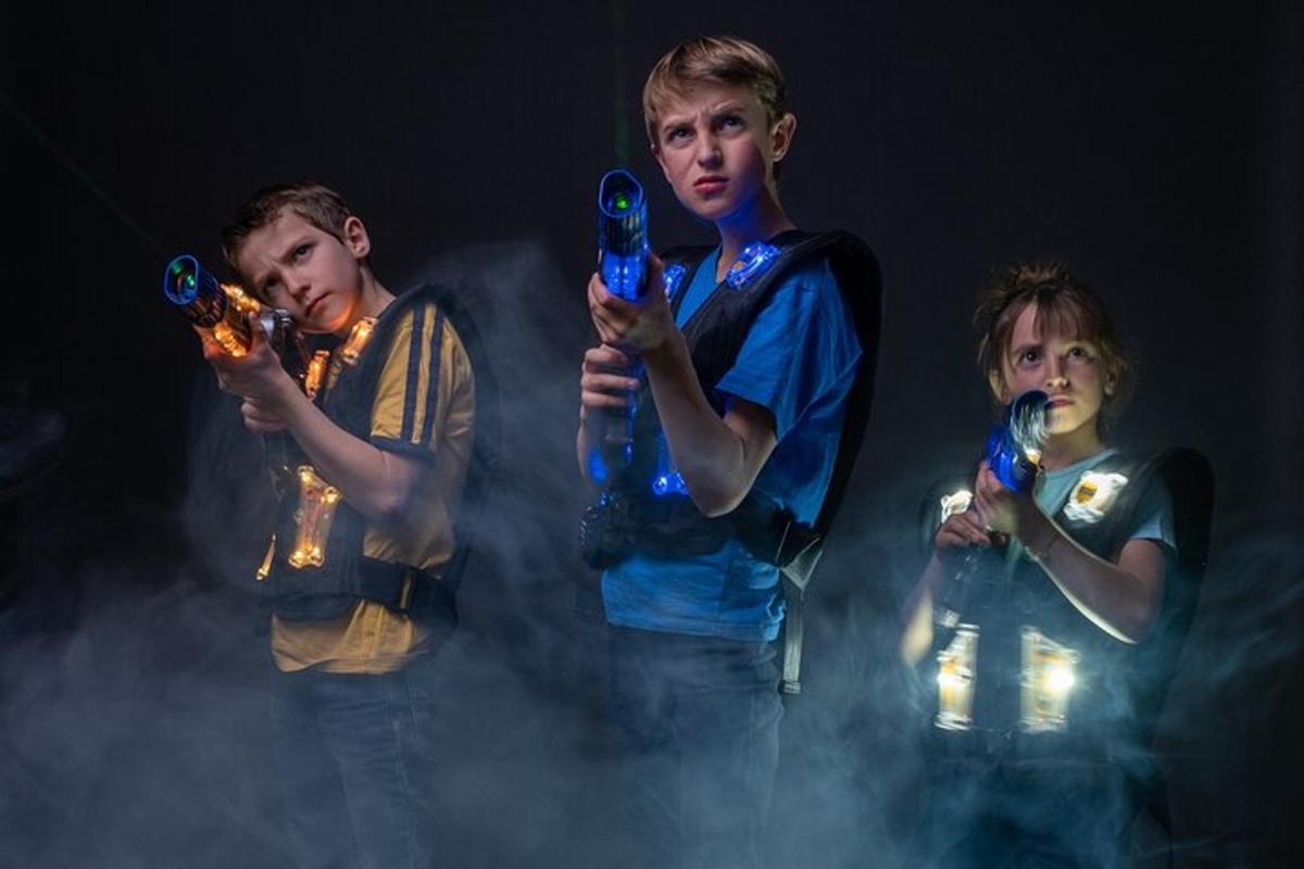 tre ragazzi che tengono in mano luci blu nel fumo