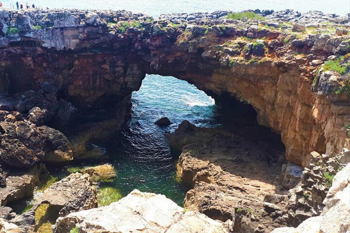 an arch in a cliff over a body of water