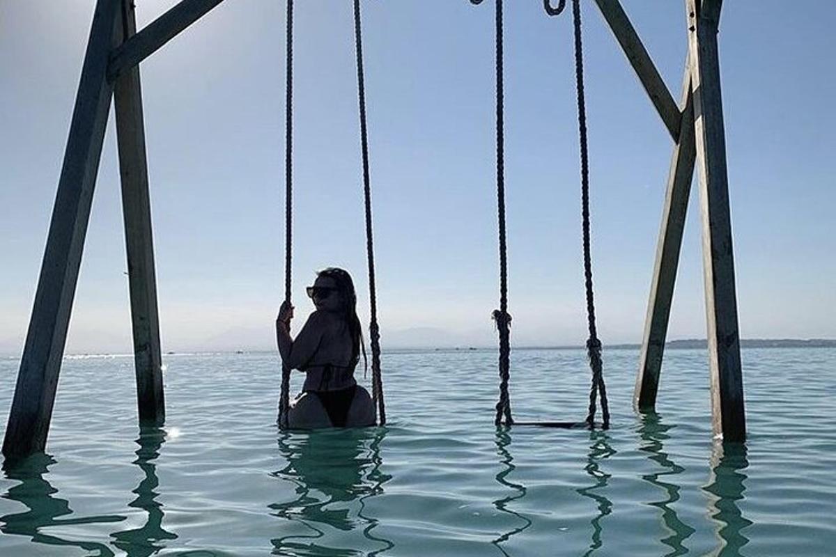 una donna seduta su un'altalena nell'acqua