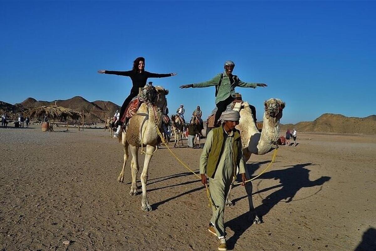 un gruppo di persone a cavallo di cammelli nel deserto