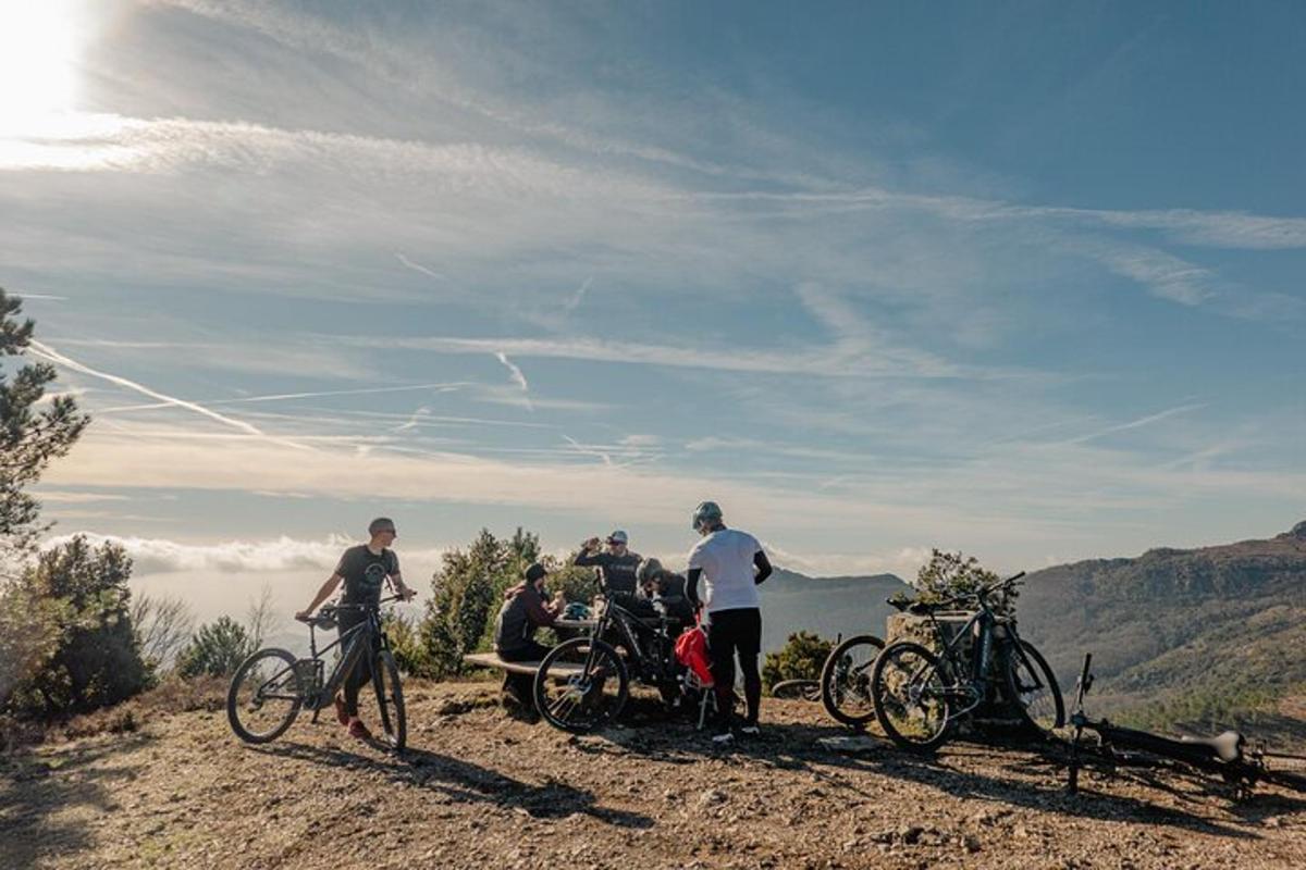 a group of people standing on a hill with bikes