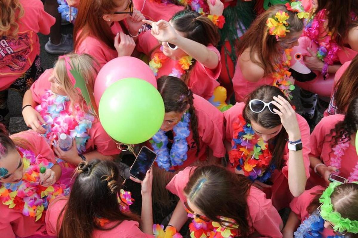 Un grupo de chicas con camisetas rosas y un globo verde.