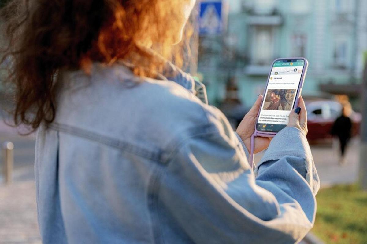 ženska gleda v svoj mobilni telefon