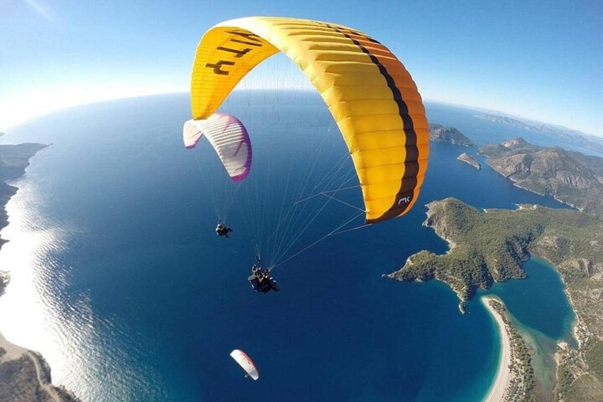 a yellow parachute flying over a body of water