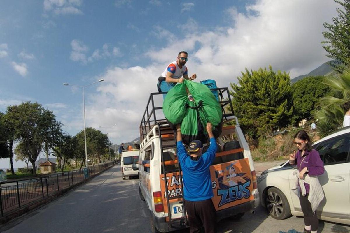 moški stoji na strehi avtobusa
