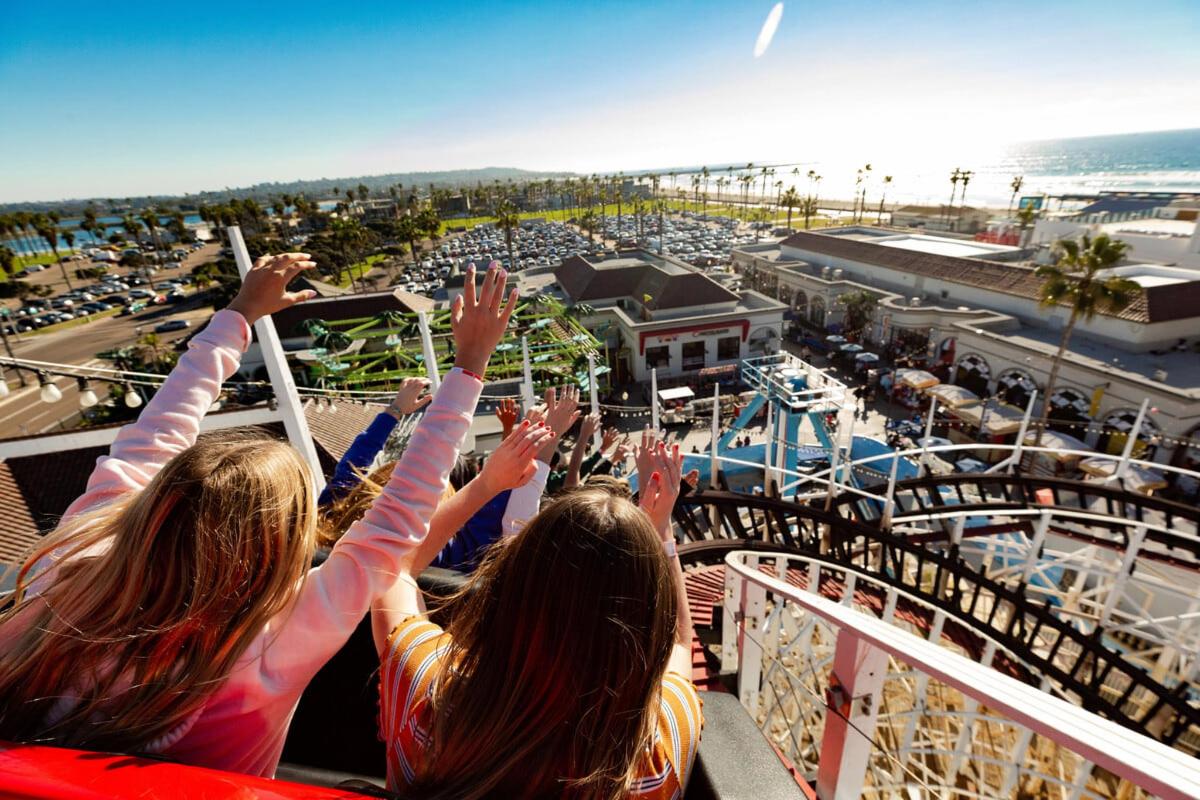 two girls on a cruise ship with their hands in the air